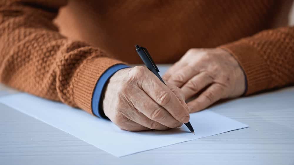 Close-up of senior man's hands writing letter