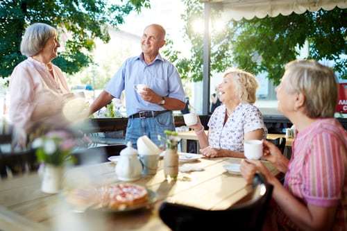 Happy senior friends having tea in an outdoor cafe