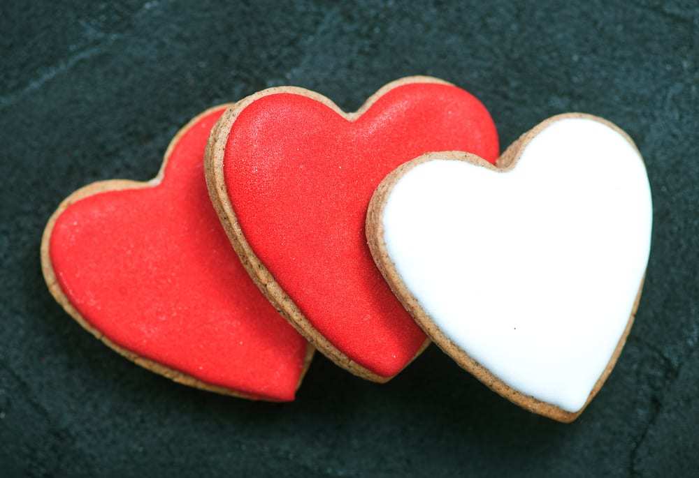 Three-heart-shaped-cookies-two-frosted-red-one-white