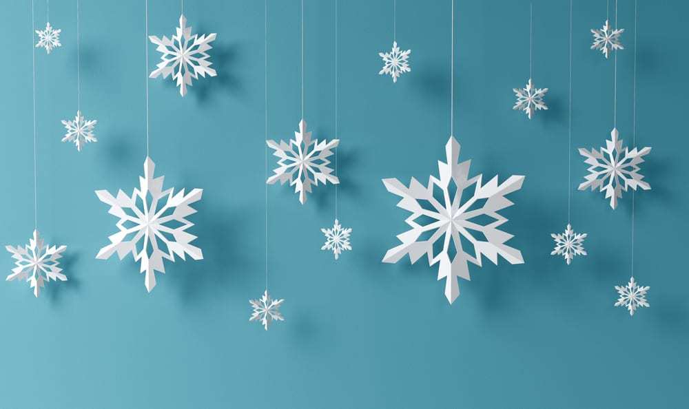 White-paper-snowflakes-hanging-in-front-of-blue-background