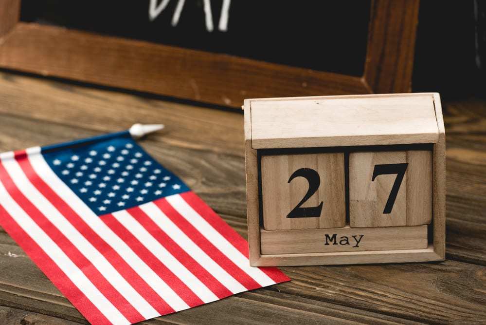 mini-american-flag-beside-a-wooden-block-calendar-showing-May-27-Memorial-Day-2019