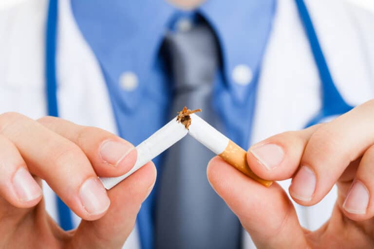Close-up of doctor breaking cigarette in half