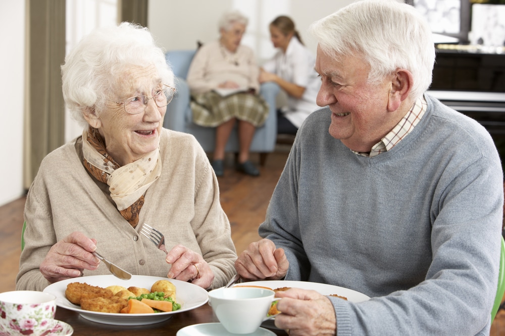 Senior couple enjoying meal together at senior living community