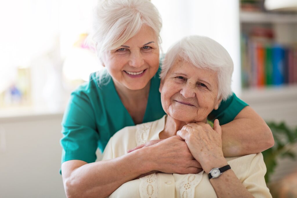 Senior woman smiling while hugging older senior woman